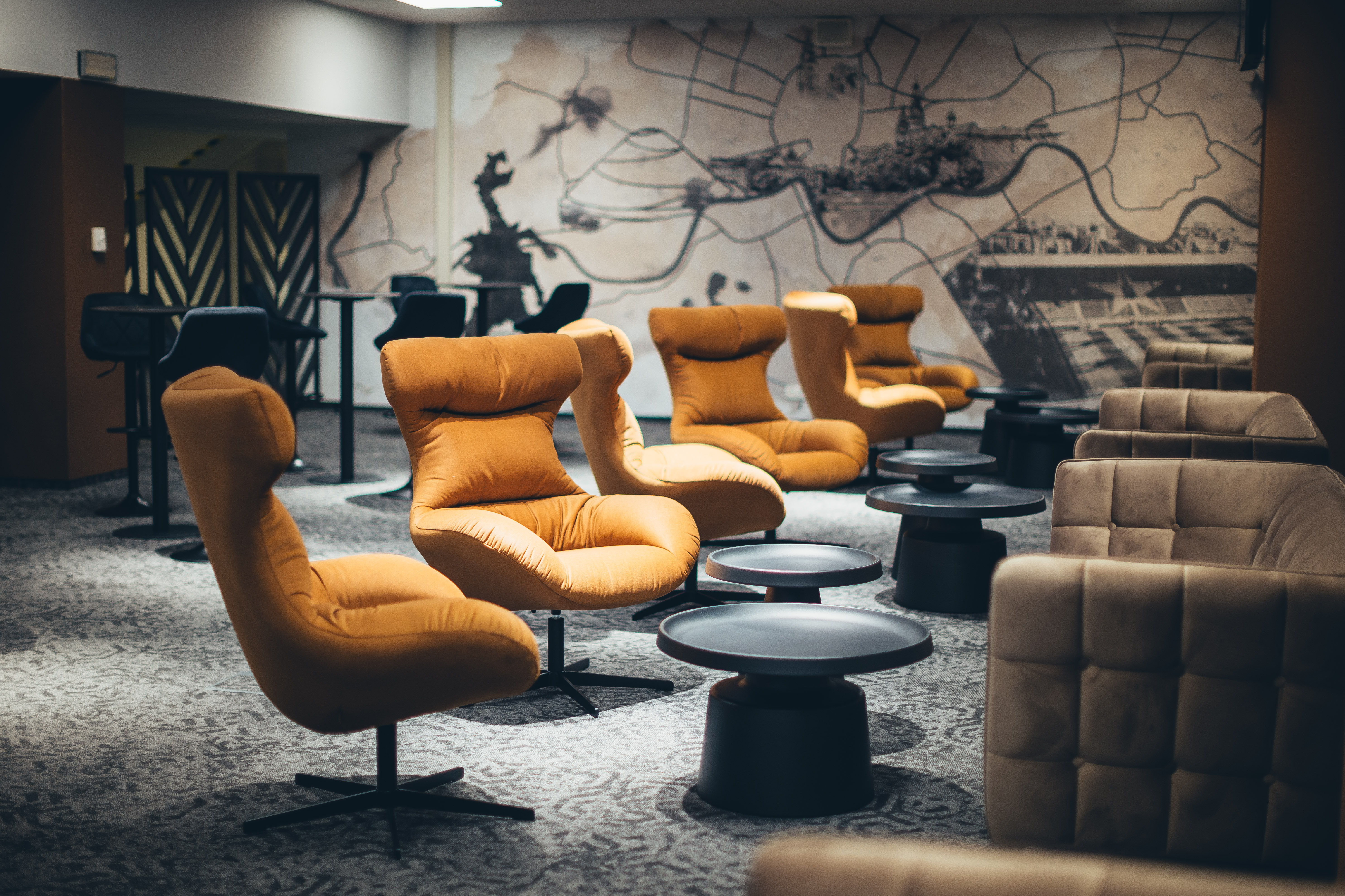 VIP Royal Lounge — orange lounge chairs in front of a hand-drawn Kraków map mural